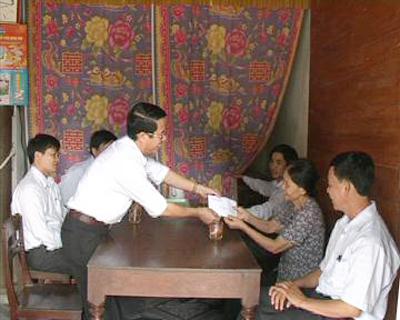 Đồng chí Hoàng Minh Đề, Chủ tịch UBND huyện Tuyên Hóa tặng quà cho gia đình chính sách
